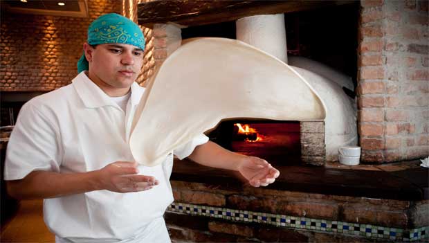 O pizzaiolo Rones Carvalho Alves abre a massa<br> O pizzaiolo Rones Carvalho Alves abre a massa<br>