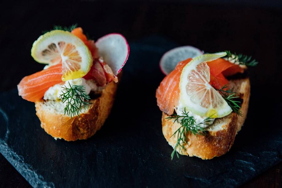 O começo: bruschettas de salmão gravlax e sour cream de limão-siciliano