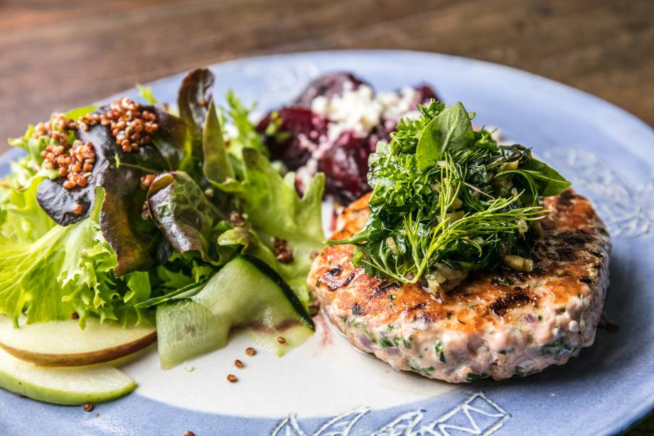 Hambúrguer de salmão, salada de folhas com pepino, maçã, quinoa e beterraba confit