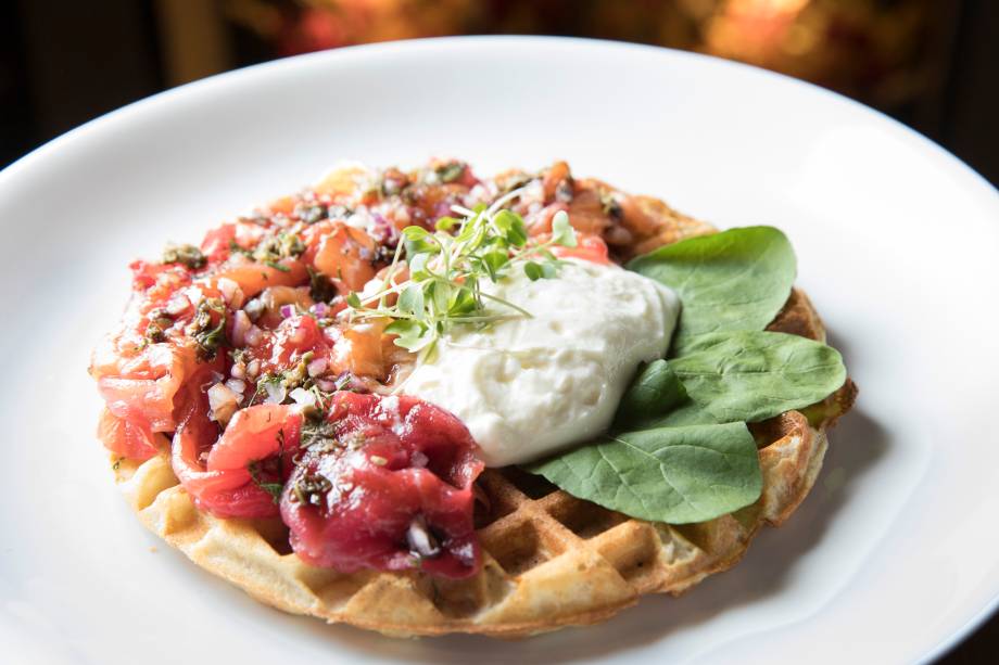 Waffle de Salmão ravlax, creme azedo, cebola-roxa, alcaparras, rúcula e redução de balsâmico (R$ 32,00)