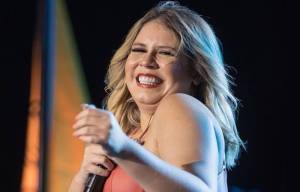 Marília Mendonça no palco, sorrindo