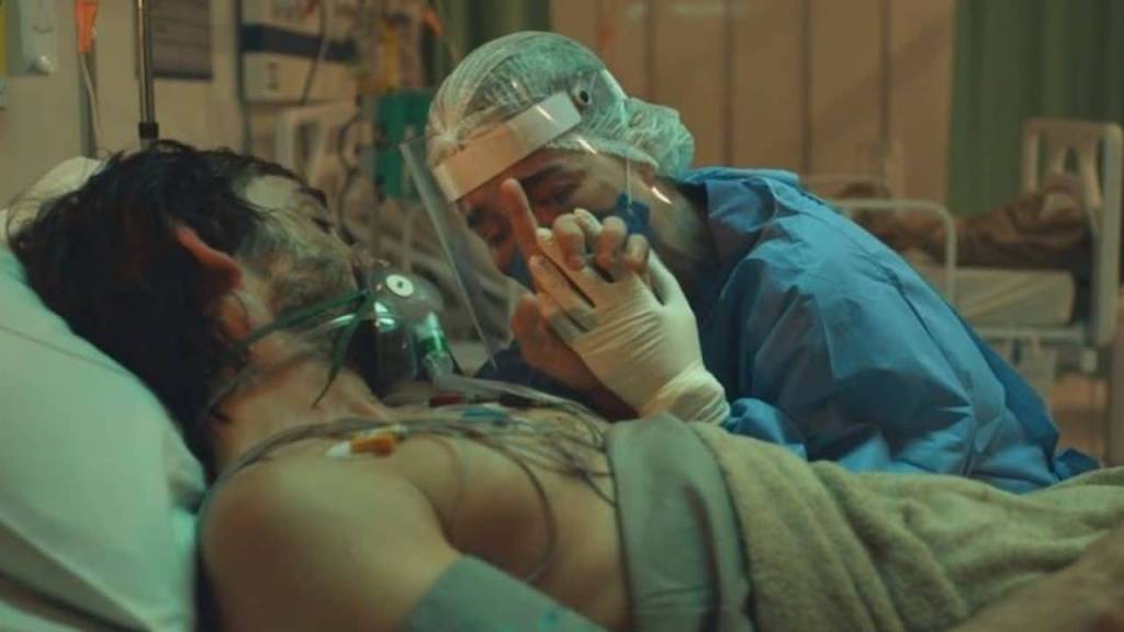 sob pressão plantao covid Personagens de Julio Andrade e Marjorie Estiano se abraçam. Ele está de máscara de oxigênio, num leito de UTI