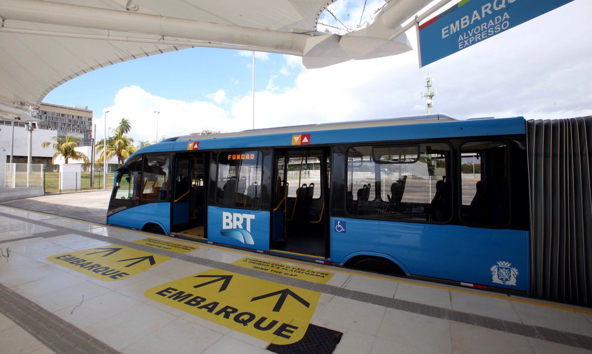Meio de transporte azul com portas abertas está parado em estação