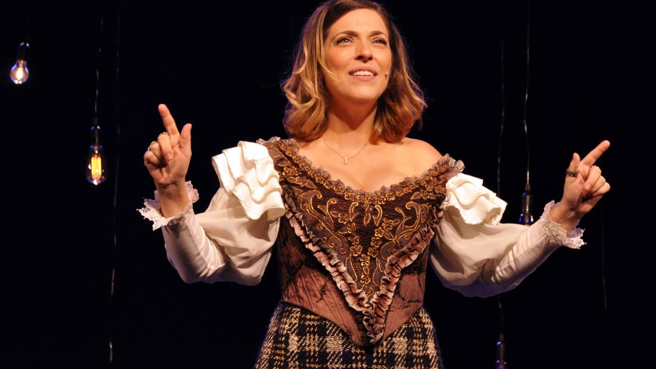 Julia Rabello no palco com as mão para cima