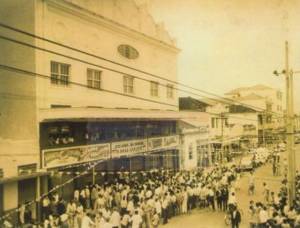 Foto em preto e branco de uma grande quantidade de pessoas na porta do Cine Guaraci, em 1953, para sua inauguração