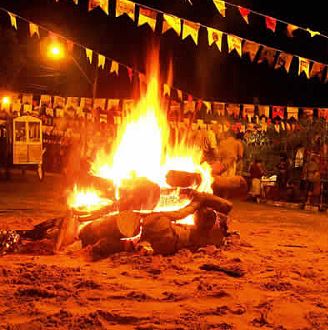 Fogueira Uma grande fogueira de São João pegando fogo entre várias bandeirinhas de Festa Junina
