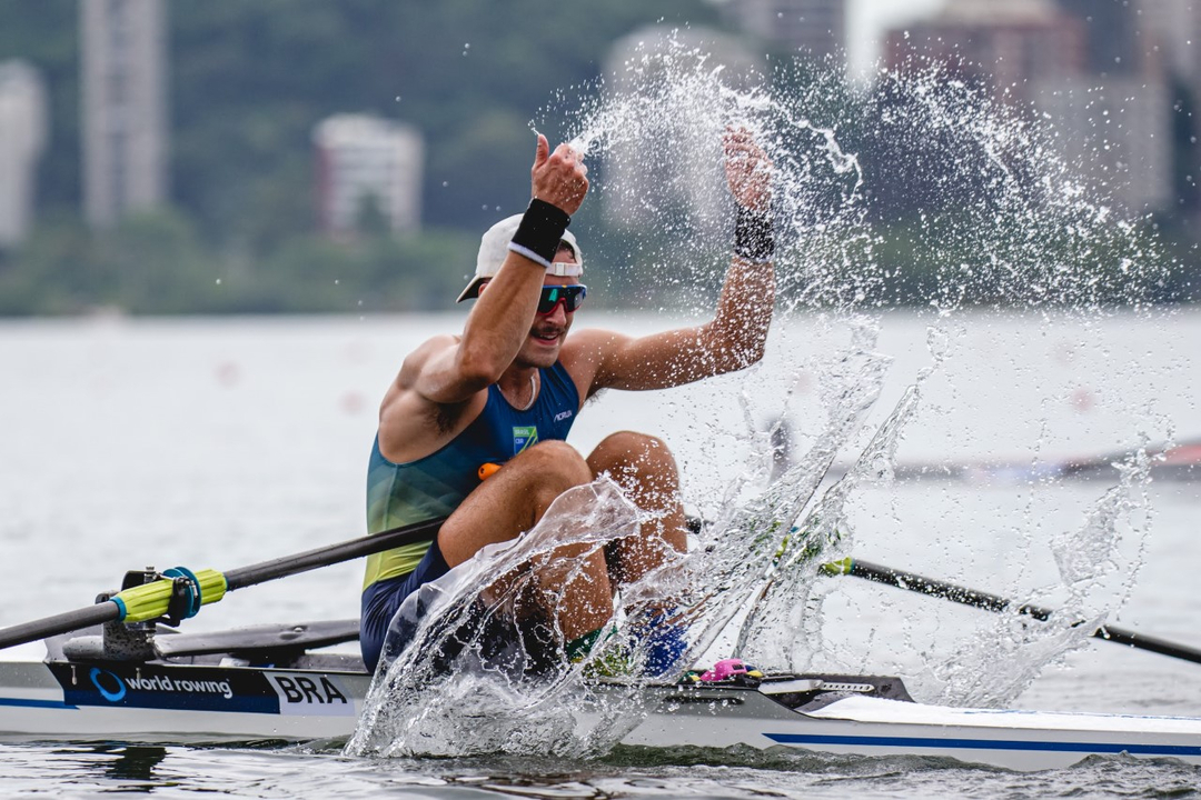Remador Lucas Verthein est&aacute; no meio da lagoa em seu remo jogando &aacute;gua para cima