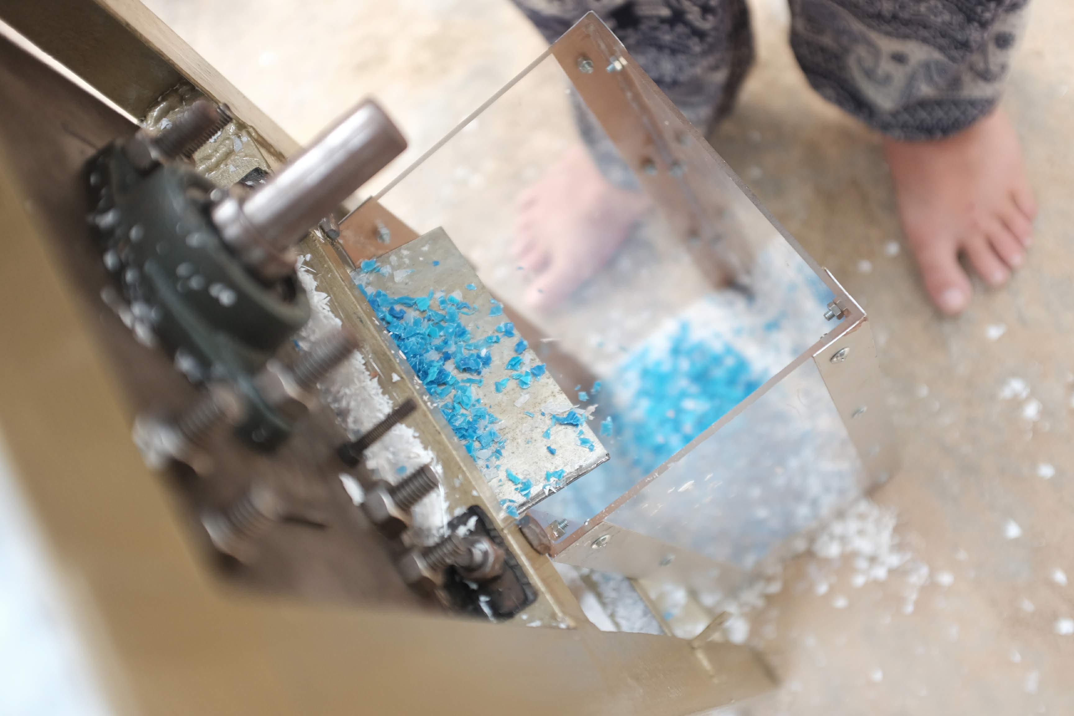 Imagem mostra pl&aacute;stico azul triturado em pequenos peda&ccedil;os