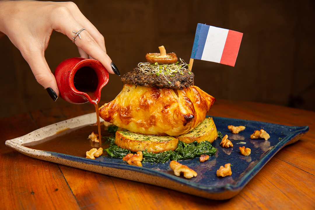 Del&iacute;rios: fil&eacute; su&iacute;no com bacon, toque de Dijon, envolto em massa folhada com crosta de ragu de cogumelos em cama de espinafre e batatas salteadas na manteiga, regado ao consomm&eacute; de cassoulet e nozes