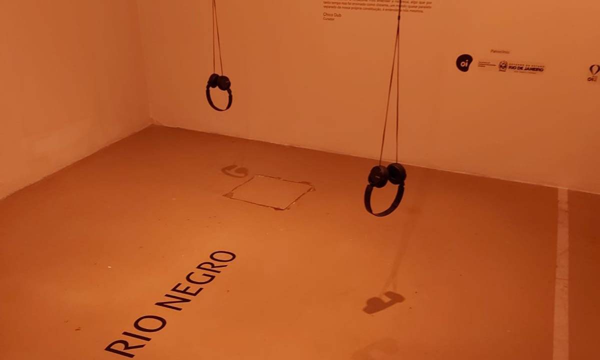 Sala do Oi Futuro com o nome Rio Negro escrito no chão e dois fones pendurados