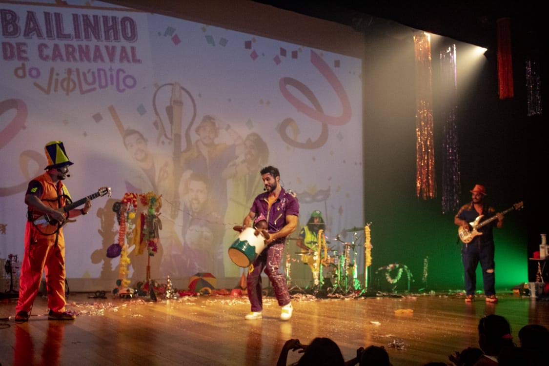 Foto mostra grupo infantil VIol&uacute;dico fazendo apresenta&ccedil;&atilde;o em palco de teatro