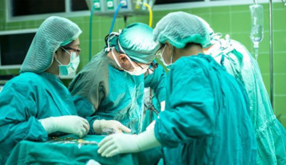 Sala de cirurgia com médicos fazendo uma operação.