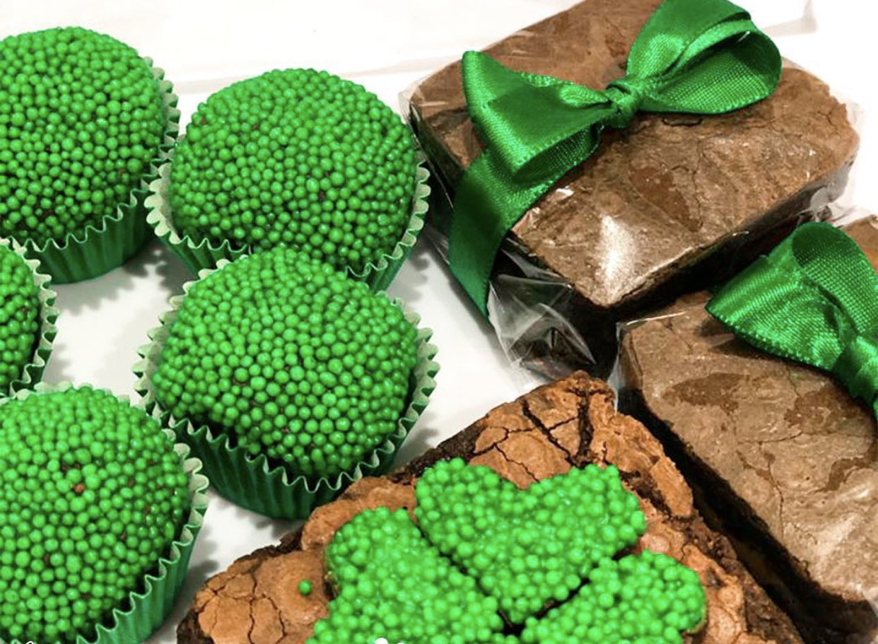 Foto mostra brigadeiros verdes e brownies embalados