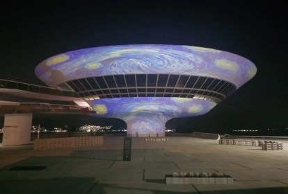 Foto mostra projeção da obra A Noite Estrelada de Van Gogh na fachada do Museu de Arte Contemporânea de Niterói, que possui formato de um disco voador