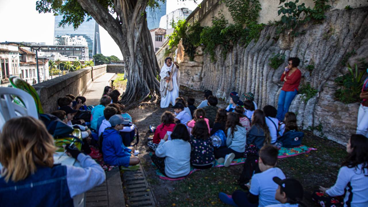 O ator e contador de histórias Tiago Viana encenando o monólogo "A criação do mundo - Cosmovisão Yorubá", no Jardim Suspenso do Valongo, em excursão escolar