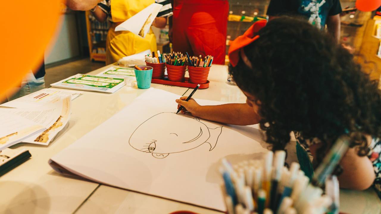 Foto mostra menina desenhando