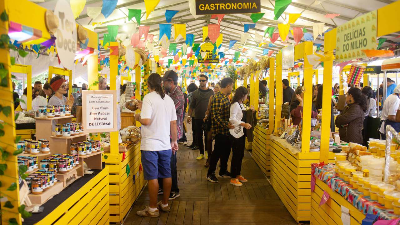 Foto mostra barraquinhas enfeitadas com bandeirolas no festival gastronômico da Babilônia Feira Hype