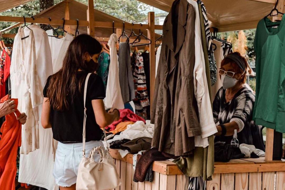 Foto mostra barraca com roupas de brechó