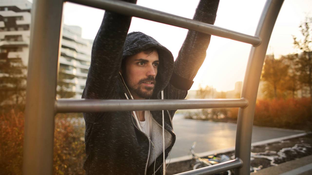 Homem se exercitando de casaco ao ar livre